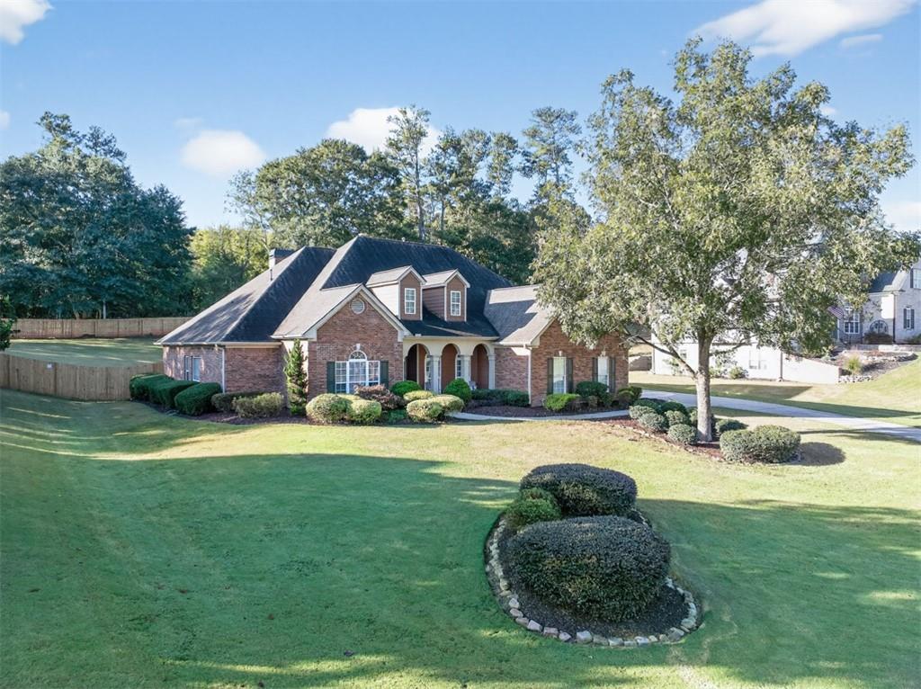 236 Reece Drive Hoschton, GA 30548 - Photo 47 of 58 a front view of a house with a garden and trees