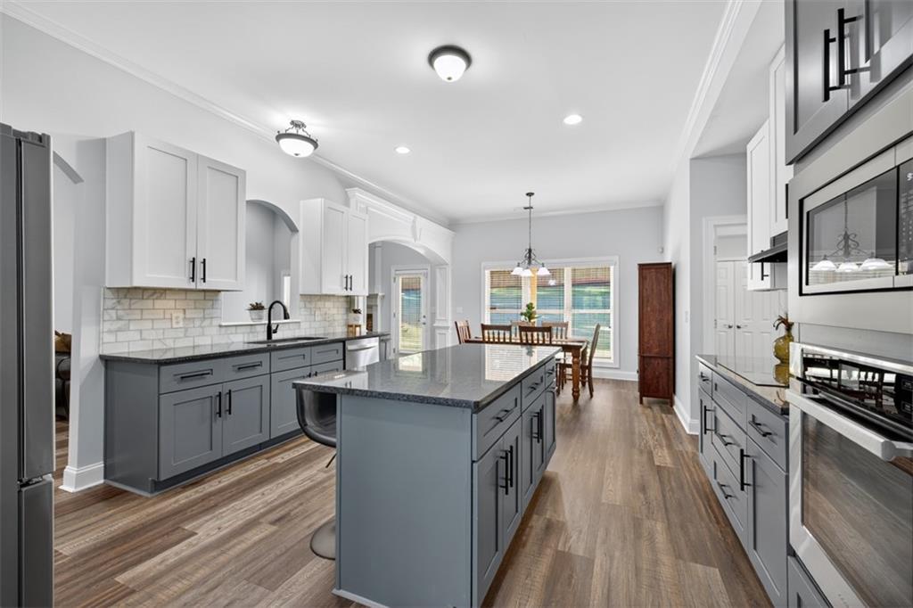 236 Reece Drive Hoschton, GA 30548 - Photo 6 of 58 a kitchen with counter top space a sink appliances and cabinets