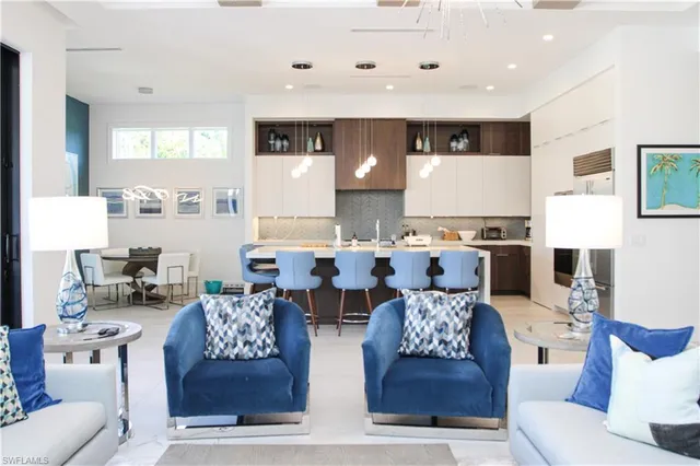 a living room with furniture kitchen view and a large window