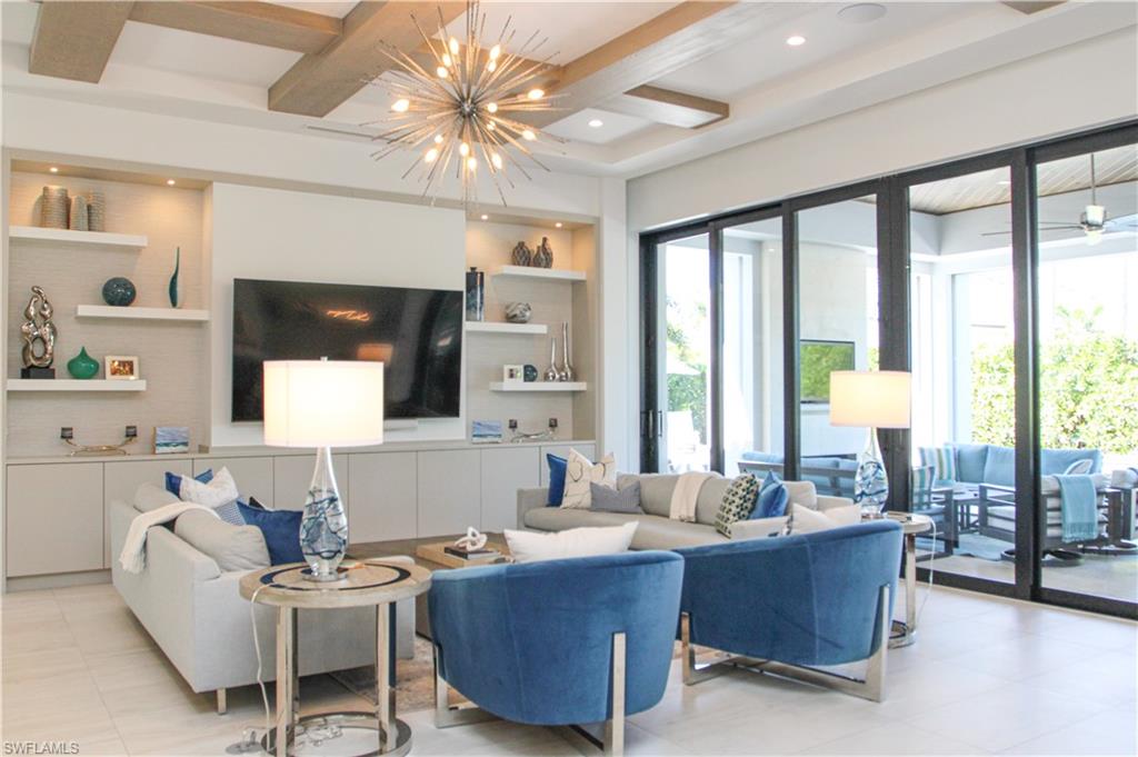 3123 Crayton Road Naples, FL 34103 - Photo 18 of 50 a living room with furniture and large windows