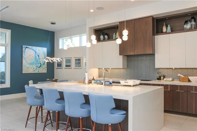 a kitchen with a dining table chairs and white cabinets
