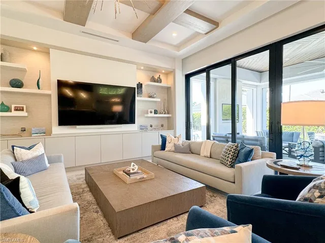 a living room with furniture a flat screen tv and a large window