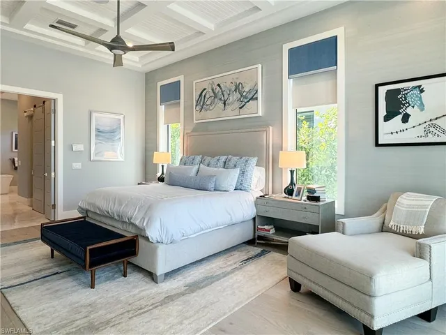 a spacious bedroom with a bed a window and a painting on the wall