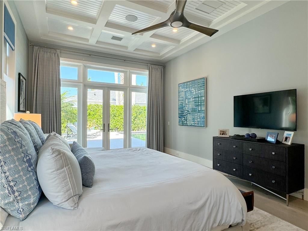 3123 Crayton Road Naples, FL 34103 - Photo 37 of 50 a bedroom with a large bed and a flat screen tv