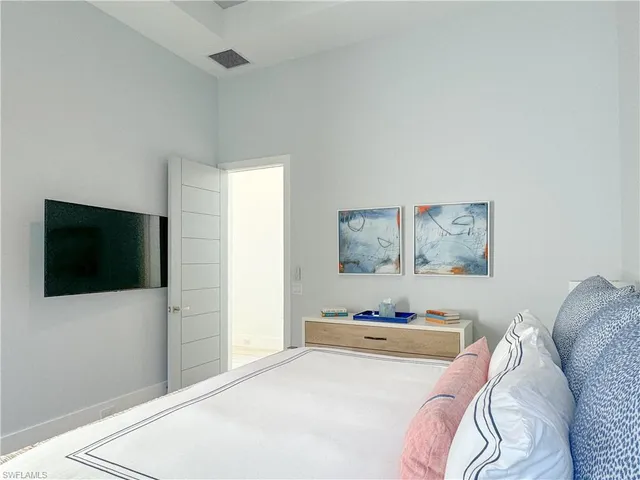 a bedroom with a bed and a flat screen tv