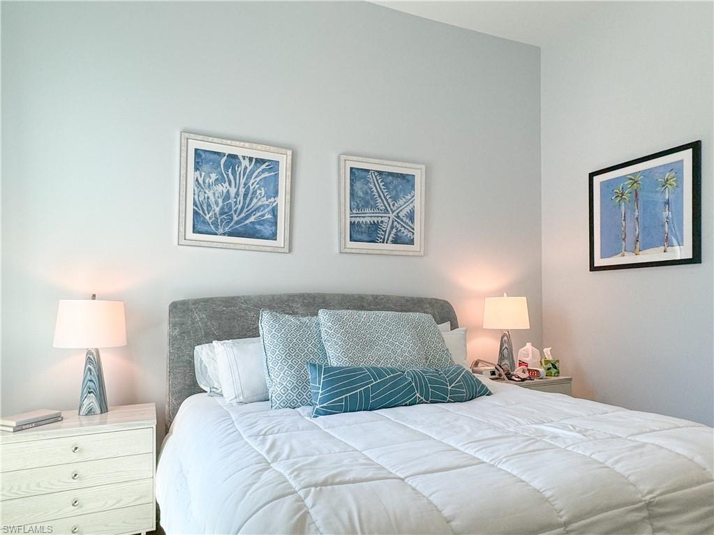 3123 Crayton Road Naples, FL 34103 - Photo 48 of 50 a bedroom with a bed and a lamp on the dresser