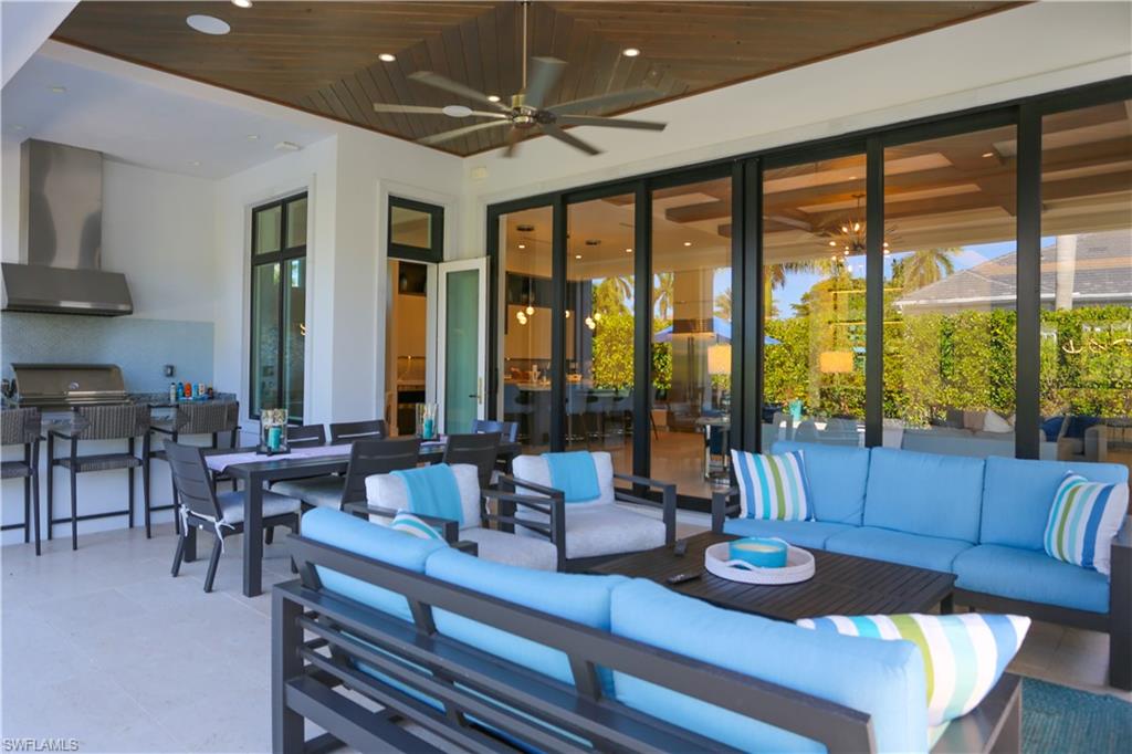 3123 Crayton Road Naples, FL 34103 - Photo 5 of 50 a living room with furniture and floor to ceiling windows