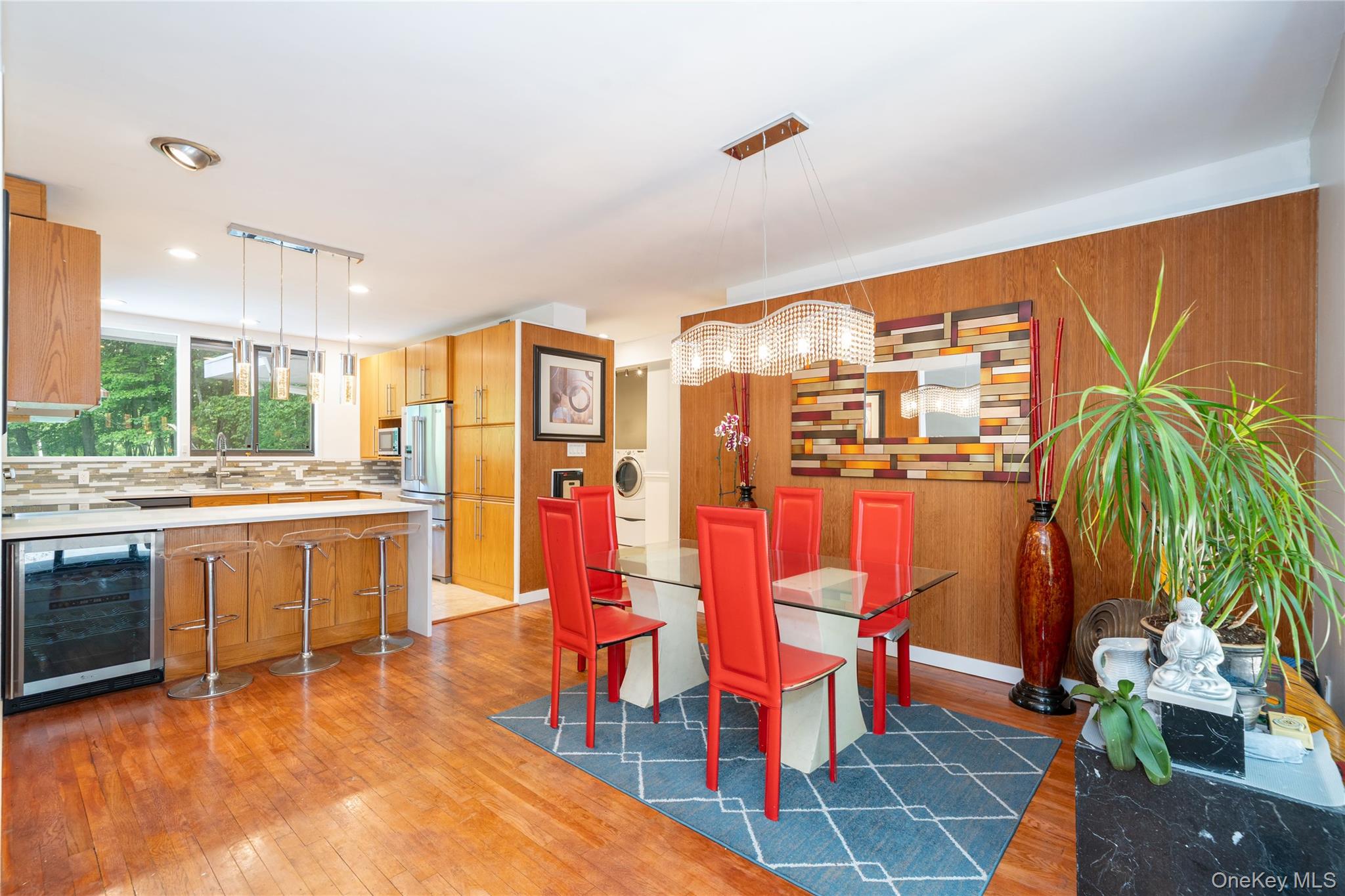 4 Half Mile Road Armonk, NY 10504 - Photo 6 of 28 Sun-filled dining area with warm hardwood floors and oversized sliding glass doors leading to an expansive outdoor deck, creating the perfect indoor-outdoor flow for entertaining.