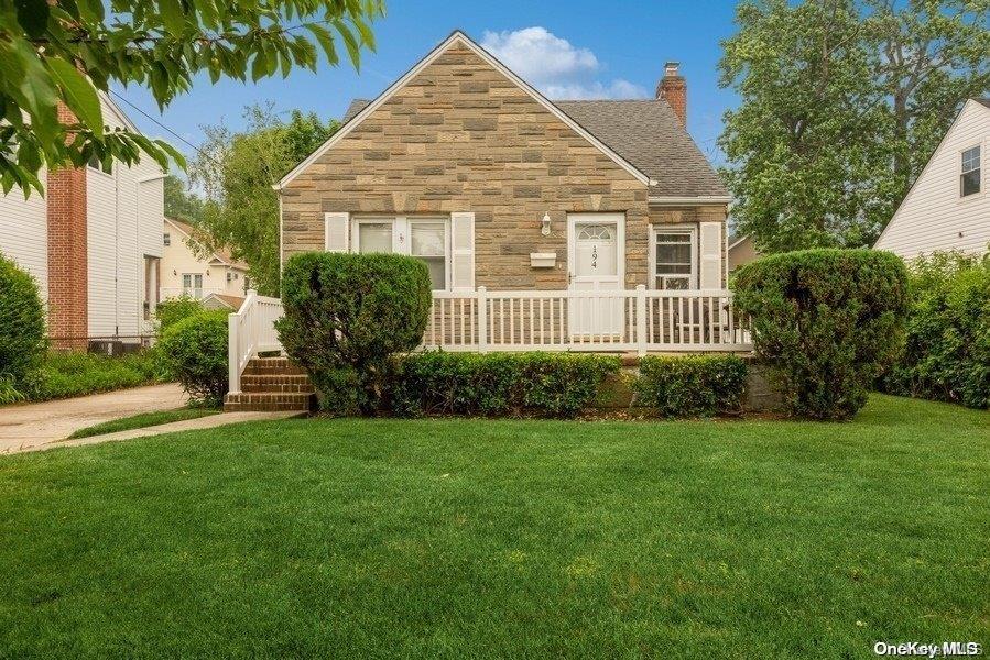 194 Roxbury Road South Garden City, NY 11530 - Photo 1 of 1 a front view of a house with a garden and porch