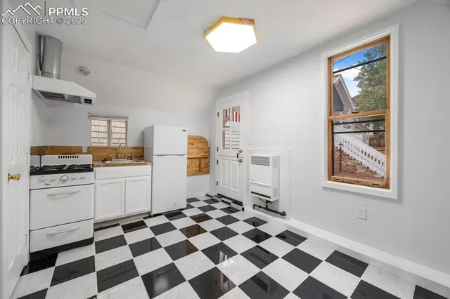a kitchen with a checkered floor and white cabinets
