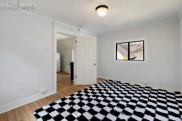 a view of a bedroom with wooden floor