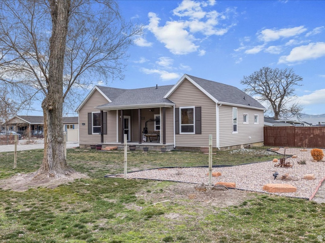 View of front of home with roof with shingles and a porch