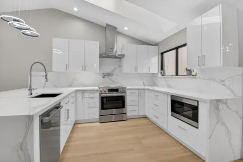 a kitchen with stainless steel appliances granite countertop a stove sink and cabinets