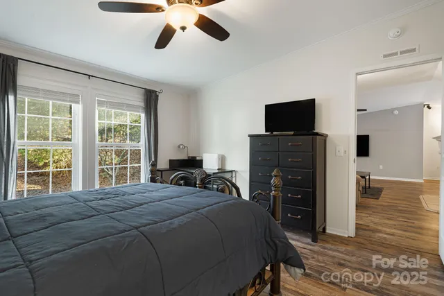 a bedroom with a bed and a flat tv screen on dresser