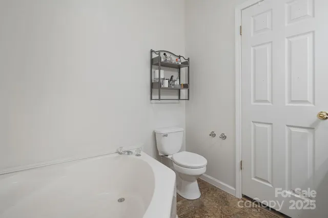 a white toilet sitting next to a white walls