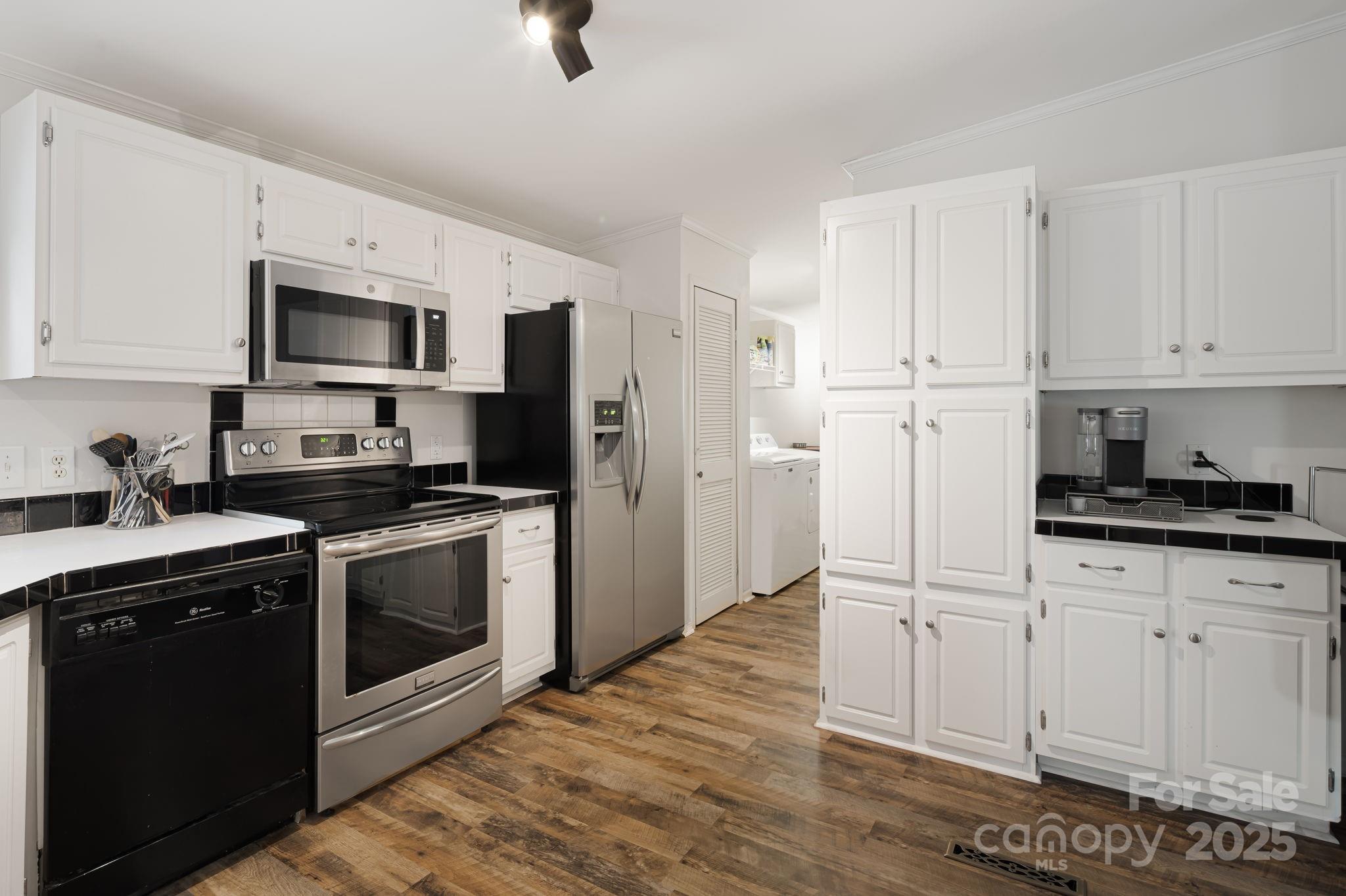 57 Founders Way Arden, NC 28704 - Photo 8 of 26 a kitchen with stainless steel appliances white cabinets a sink a stove a refrigerator and microwave