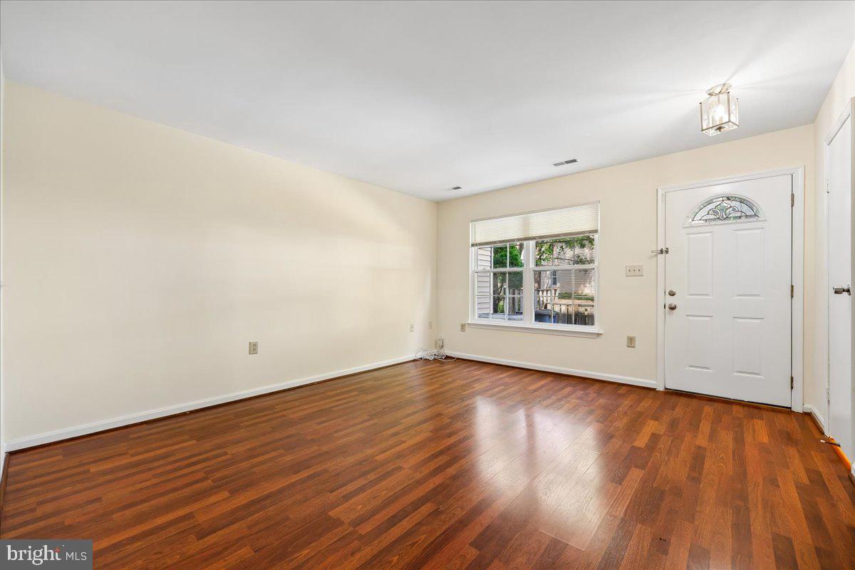 18012 Golden Spring Court, Unit 239 Olney, MD 20832 - Photo 11 of 44 an empty room with wooden floor and windows