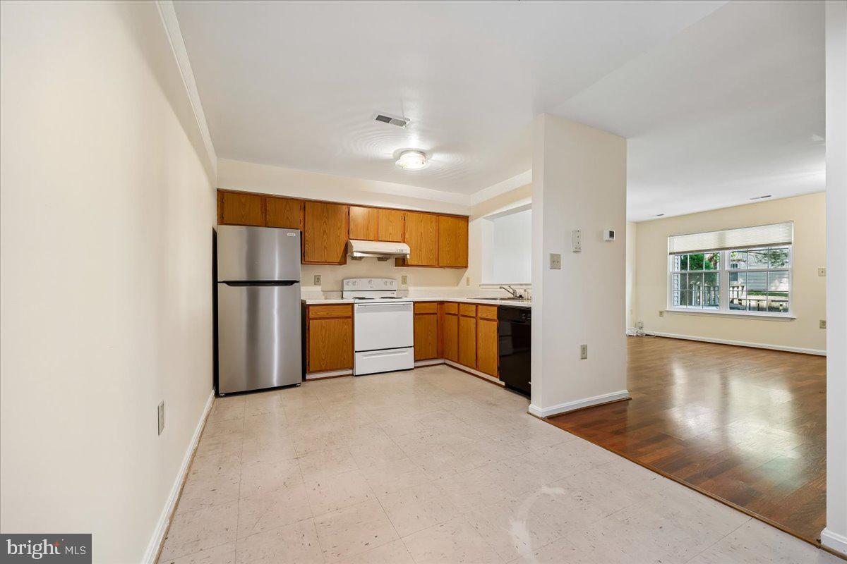 18012 Golden Spring Court, Unit 239 Olney, MD 20832 - Photo 13 of 44 a kitchen with stainless steel appliances a refrigerator and a stove top oven