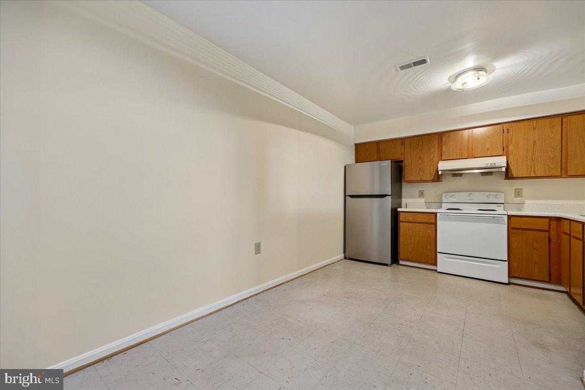 18012 Golden Spring Court, Unit 239 Olney, MD 20832 - Photo 14 of 44 a kitchen with white cabinets and white appliances