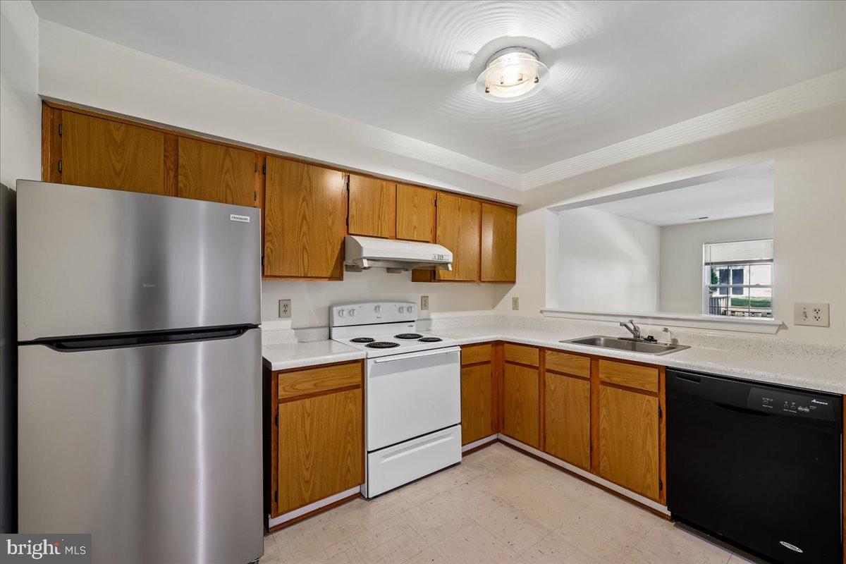 18012 Golden Spring Court, Unit 239 Olney, MD 20832 - Photo 15 of 44 a white refrigerator freezer sitting in a kitchen