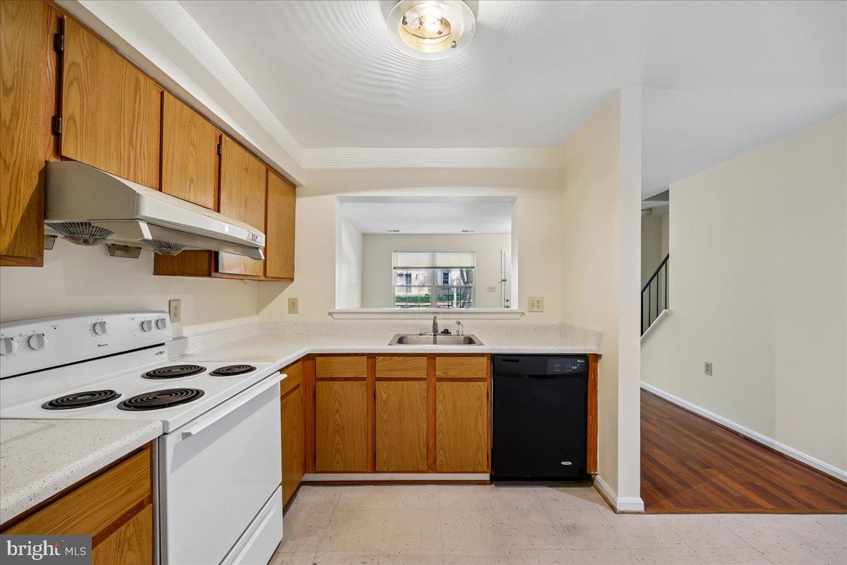 18012 Golden Spring Court, Unit 239 Olney, MD 20832 - Photo 16 of 44 a kitchen with a sink a stove and cabinets