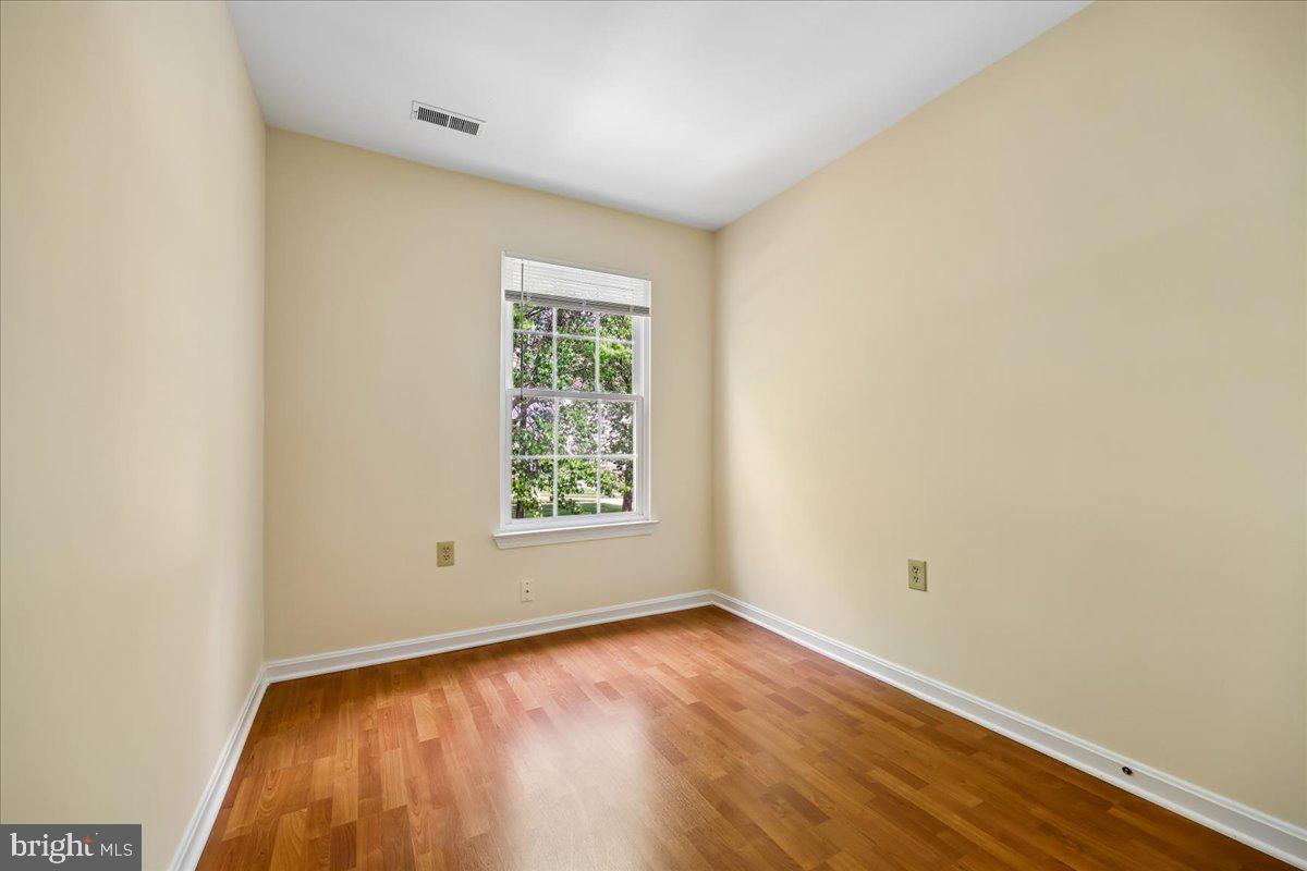 18012 Golden Spring Court, Unit 239 Olney, MD 20832 - Photo 27 of 44 an empty room with wooden floor and windows