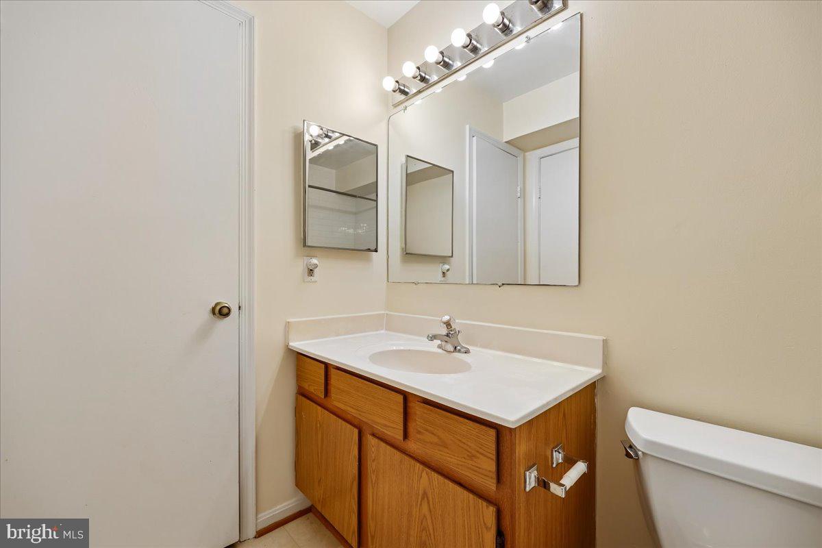 18012 Golden Spring Court, Unit 239 Olney, MD 20832 - Photo 32 of 44 a bathroom with a sink toilet a mirror and vanity