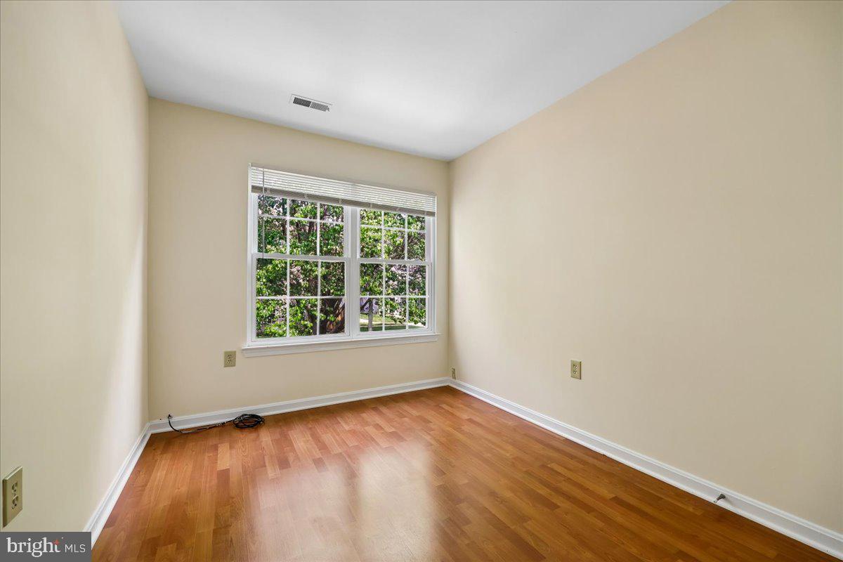 18012 Golden Spring Court, Unit 239 Olney, MD 20832 - Photo 36 of 44 an empty room with wooden floor and windows
