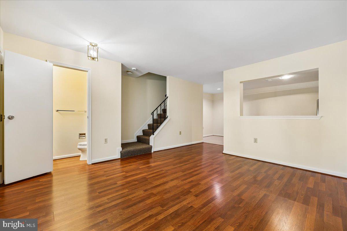 18012 Golden Spring Court, Unit 239 Olney, MD 20832 - Photo 8 of 44 an empty room with wooden floor and windows