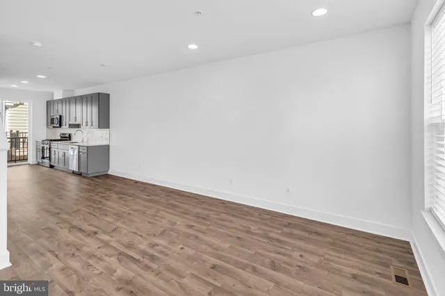 a view of empty room with wooden floor and window