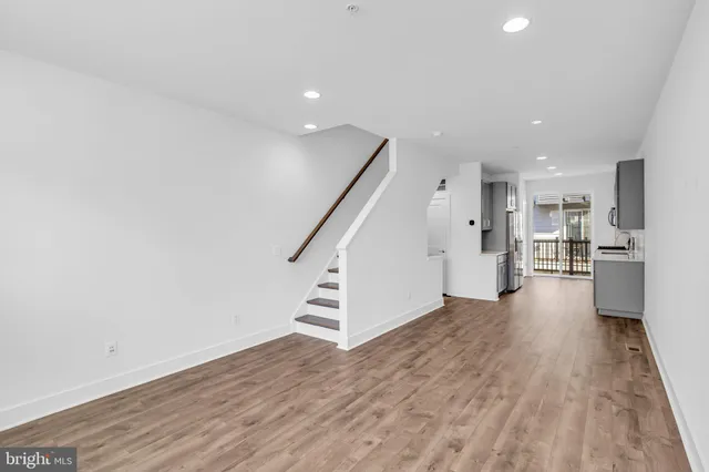 a view of a kitchen with wooden floor and electronic appliances