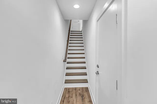 a view of hallway with stairs and wooden floor