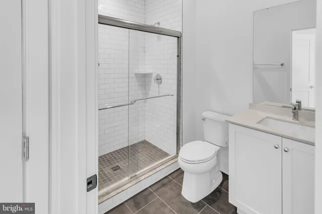 a bathroom with a granite countertop toilet and a sink