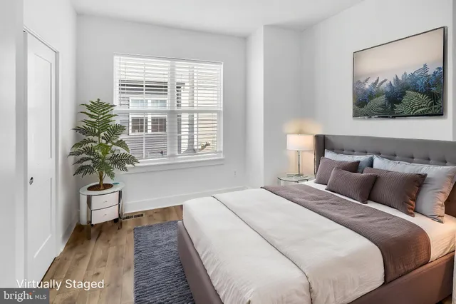 a bedroom with bed and a potted plant