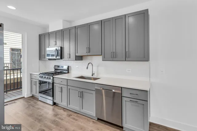 a kitchen with stainless steel appliances granite countertop a sink stove and cabinets
