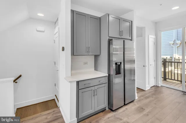 a kitchen with white cabinets and refrigerator