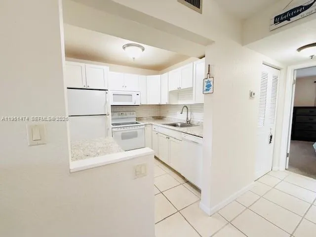 a kitchen with white cabinets and white appliances