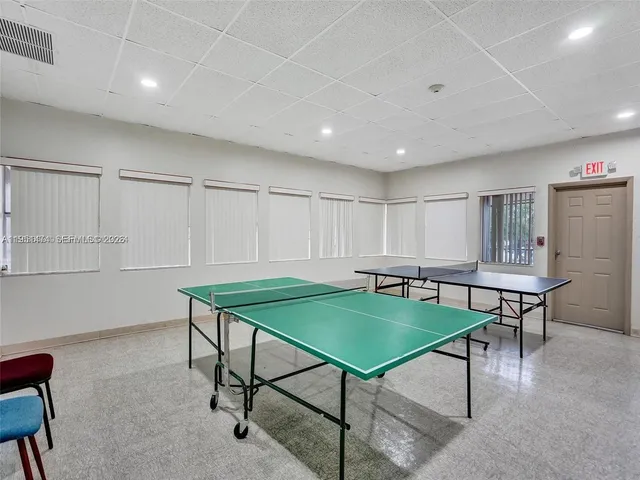 a room with furniture pool table and windows