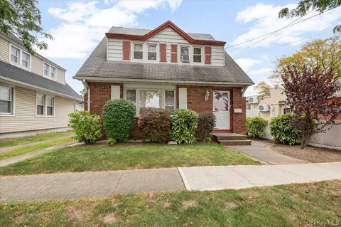 a front view of a house with a garden and yard