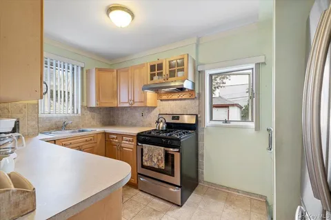 a kitchen with granite countertop a stove sink and cabinets