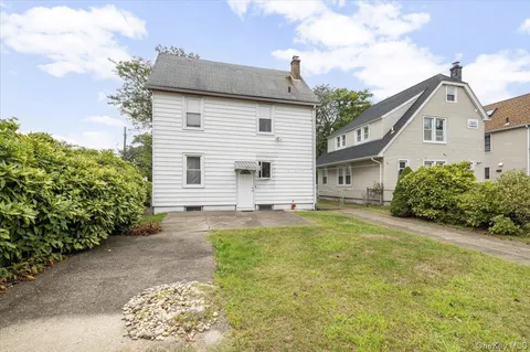 a view of a hallway with wooden floor and a bathroom