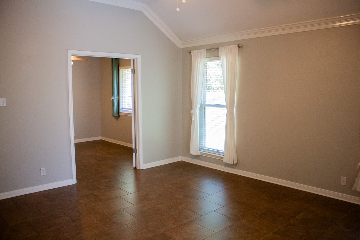 12721 Oxen Way Austin, TX 78732 - Photo 14 of 37 an empty room with wooden floor and windows with curtains
