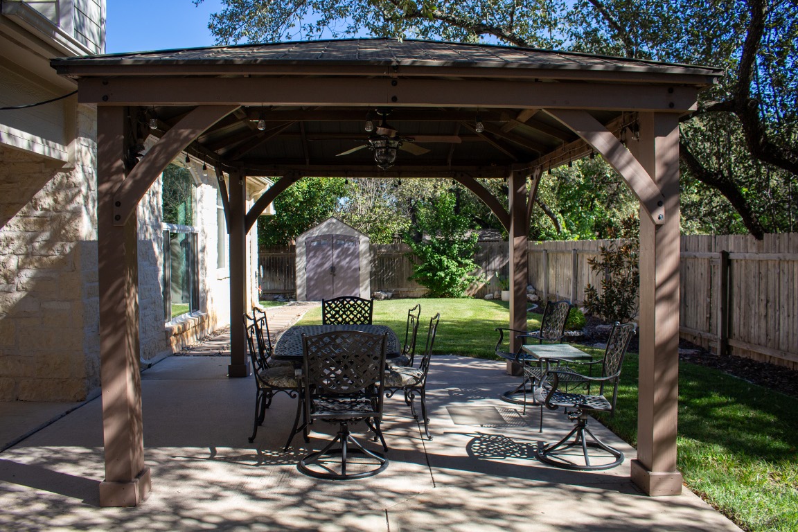 12721 Oxen Way Austin, TX 78732 - Photo 24 of 37 a patio with wooden floor a yard a table and chairs