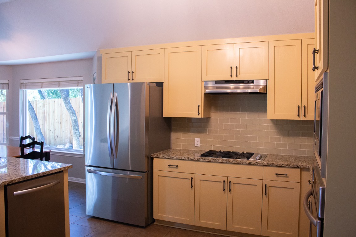 12721 Oxen Way Austin, TX 78732 - Photo 8 of 37 a kitchen with appliances a sink and a window
