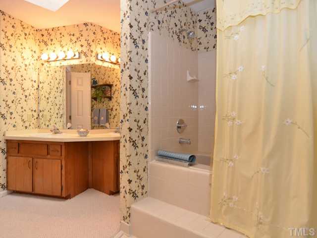 909 Bridge Way Raleigh, NC 27615 - Photo 15 of 22 a bathroom with a bathtub and a shower