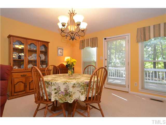 909 Bridge Way Raleigh, NC 27615 - Photo 8 of 22 a view of a dining room with furniture a chandelier and a window
