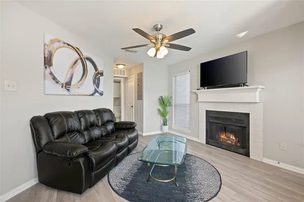 a living room with furniture a fireplace and a flat screen tv