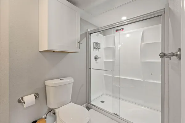 a bathroom with a shower a toilet and a sink