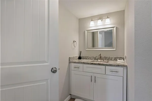 a bathroom with a granite countertop sink a toilet and a mirror