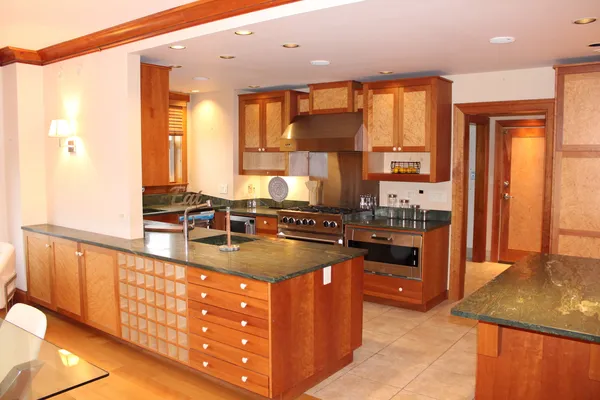 a kitchen with stainless steel appliances granite countertop a sink a stove and a refrigerator